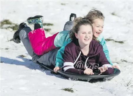  ??  ?? Tayvia Hamilton, 12, and sister Elsie Hamilton, 7, take to the hills in Beacon Hill Park in Victoria on Tuesday. Schools in the Sooke and Saanich districts were closed, while those in the Greater Victoria district remained open.