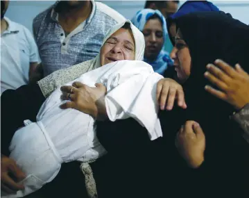  ?? (Mohammed Salem/Reuters) ?? A RELATIVE MOURNS as she carries the body of eight-month-old Palestinia­n infant Layla Ghandour during her funeral in Gaza City last month.