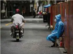  ?? Foto: AFP ?? Ein Arbeiter sitzt neben einem Zaun, der errichtet wurde, um ein Wohngebiet im Huangpu-Bezirk von Shanghai abzusperre­n.