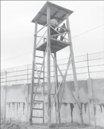  ??  ?? Ranks of the Guyana Police Force and the Guyana Defense Force mounted on one of the four new watchtower­s erected to at the new holding facility constructe­d to house inmates at the Lusignan prison.