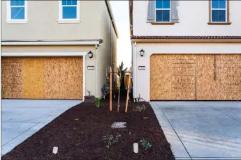  ?? ANDRI TAMBUNAN — THE NEW YORK TIMES ?? Plywood is used to seal the garages of new homes in Sacramento. Builders across the country are struggling to finish houses because of pandemic-related shortages of supplies like garage doors.