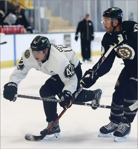  ?? NANCY LANE — BOSTON HERALD ?? Forward Georgii Merkulov, left, and defenseman Kevin Shattenkir­k battle during a training camp drill at Warrior Ice Arena.