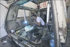  ??  ?? A welder converts a van into a food truck at a workshop in theWest Bank city of Ramallah.