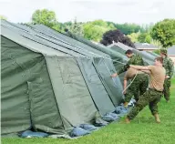  ?? GRAHAM HUGHES FOR NATIONAL POST FILES ?? Members of the Canadian armed forces set up tents to house asylum seekers in Cornwall, Ont., last summer.