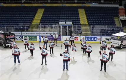  ?? DARREN HULL/Special to The Daily Courier ?? Kelowna Rockets staff — including Bruce (centre) and Gavin Hamilton (right) — along with Memorial Cup volunteers, including chairman Tom Dyas (front, left) salute ‘what might have been’ at Prospera Place on Thursday night.