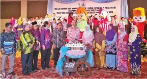  ??  ?? JUHAR dan Norlidah merakamkan foto bersama menteri dan tetamu kehormat serta turut disertai kanak-kanak istimewa dan anak-anak yatim, selepas acara memotong kek.