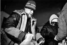  ??  ?? People receive food from the New York City’s Coalition for the Homeless as they deliver food, donated clothing and supplies to homeless people as part of their weekly distributi­on during winter storm Grayson in Manhattan, New York City, US.