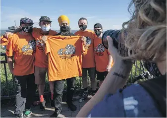  ?? THE CANADIAN PRESS ?? NDP Leader Jagmeet Singh gets his picture taken as he is presented with a T-shirt in support of Indigenous children and residentia­l school survivors, in Hamilton, Ont. on Monday.