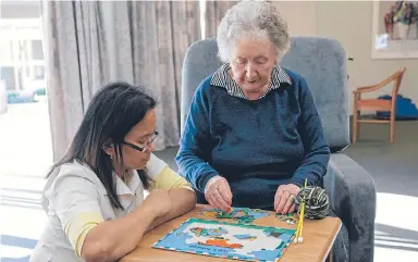  ??  ?? The centre’s Clinical Nurse Leader, Carmela, encourages a resident to complete a jigsaw puzzle.