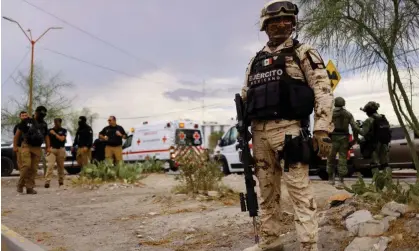  ?? Juárez. Photograph: José Luis González/Reuters ?? Security forces stand guard outside the Cereso number 3 state prison after a fight between imprisoned members of rival gangs, in Ciudad