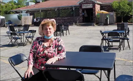  ?? Joseph B. Nadeau photos/The Call ?? Bethany Marsland, the owner of Fazzini’s Restaurant at 2120 Diamond Hill Road, tries out a table before the restaurant’s new outdoor dining set-up debuted Friday evening. Fazzini’s staff will be serving customers from a special country BBQ menu as the new service option begins in the parking area behind the restaurant. Take-out service will also continue.