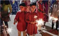  ??  ?? Rashiv Salooja and Ishaan Brahmbhatt, both 7, hold sparklers as they take part in the Diwali Mele celebratio­n at the Hindu Temple of The Woodlands.