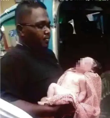  ?? PIC COURTESY OF THAYALAN PALIANDY ?? Thayalan Paliandy with the baby who was thrown out from the second floor of a building in Kajang.