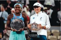  ?? THIBAULT CAMUS/ASSOCIATED PRESS ?? French Open champion Iga Swiatek, right, and runner-up Coco Gauff display their trophies after Swiatek’s dominant, straightse­t victory in the women’s final on Saturday.