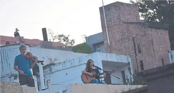  ?? (JAVIER FERREYRA) ?? Como los Beatles. Cada tarde, Guadalupe Gómez y Julio Gutiérrez sorprenden en barrio Observator­io con música en vivo.