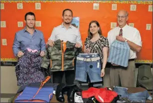  ?? The Sentinel-Record/Richard Rasmussen ?? WINDOWS DRESSING: A $10,000 donation from Windows USA and Window Mart owners, from left, Ryan Guthrie and Eric Oliver, both graduates of Mountain Pine, to the Mountain Pine Elementary School’s Counseling Fund will help provide clothes, shoes, backpacks...