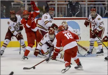  ?? GREG M. COOPER — THE ASSOCIATED PRESS ?? Cornell’s Kyler Kovich (18) takes a shot on goal while defended by Denver’s Tristan Broz (16) in the second period of their NCAA Tournament game Thursday in Manchester, N.H.