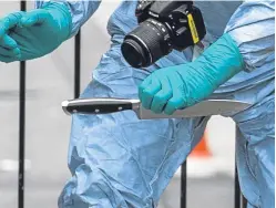  ?? PA. ?? A forensics officer recovers a knife from the scene.