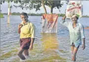  ?? RAJ K RAJ/HT ?? People wade through inundated streets on the outskirts of Kuttanadu region in Kerala’s Alappuzha on Tuesday.