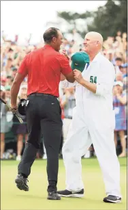  ?? Andrew Redington / Getty Images ?? Tiger Woods, left, celebrates with caddie Joe LaCava on the 18th green after winning the 2019 Masters at Augusta National Golf Club.