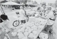  ?? — Gambar Bernama ?? RESIPI KAMPUNG BARU: Orang ramai mula mengambil bubur lambuk percuma secara pandu lalu seawal 2 petang di Kampung Bukit Piatu, Kuala Lumpur semalam. Agihan secara pandu lalu itu bermula pada Ramadan tahun lepas ketika negara dikenakan Perintah Kawalan Pergerakan (PKP) bagi mengelak orang ramai beratur panjang untuk mendapatka­n bubur lambuk tersebut. Resipi yang diambil dari Masjid Jamek Kampung Baru, Kuala Lumpur itu sangat dinanti-nantikan ramai orang terutama penduduk setempat tatkala tibanya Ramadan. Kira-kira 500 bungkus bubur lambuk sehari akan diagihkan kepada orang ramai.