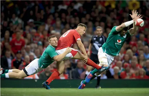  ?? AP ?? Jarrod Evans clears the ball for Wales under pressure from two Irish players during the match in Cardiff.