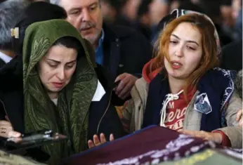  ?? UMIT BEKTAS PHOTOS/REUTERS ?? Burcu and Burcin Cetinkaya, daughters of one of the 37 victims of a suicide car bombing in the heart of the capital city of Ankara on Sunday, weep over their mother’s coffin during her funeral ceremony yesterday.