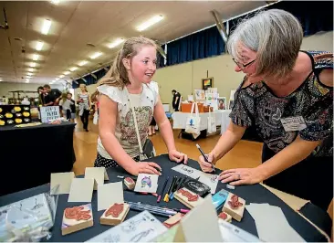  ?? PHOTO: DAVID UNWIN/ FAIRFAX NZ ?? Anika Currie, 10, enjoying Jenny Humphreys’ Stampin Up stall at the fair.