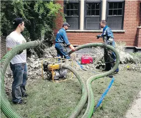  ?? BRIDGETTE HANSON ?? Volunteer Dana Hanson, left, helps brothers Jason, centre, and Trent Field drainand clean waterlogge­d houses in Calgary after the 2013 flood.