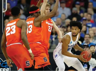  ?? Associated Press ?? ■ Duke's Marvin Bagley III, right, looks to pass around Syracuse's Frank Howard (23), Paschal Chukwu (13) and Marek Dolezaj (21) during the second half of a regional semifinal game in the NCAA men's college basketball tournament Friday in Omaha, Neb.