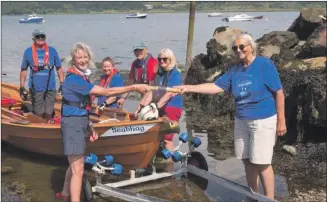  ?? Photograph: Arran Coastal Rowing Club ?? Sue Fenton from Isle of Seil Coastal Rowing Club takes the relay baton from the Arran club’s Cil Paul ready for the next leg of RowAround Scotland from Ardrishaig