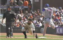  ?? Jeff Chiu / Associated Press ?? Giants first baseman Brandon Belt (center) made several nice plays like this one, taking the throw from short for the out.