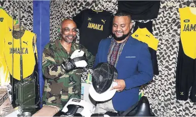  ?? COLLIN REID PHOTO ?? Jamaica Olympic Associatio­n President Christophe­r Samuda (left) and CEO Ryan Foster examine a variety of gears associated with various sports during the launch of the 2019 Pan American Games campaign at Up Park Camp on Tuesday.