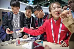  ?? AP Photo/Mark Schiefelbe­in ?? ■ An exhibitor talks about Huawei smartphone­s at the PT Expo technology conference Oct. 31, 2019, in Beijing.