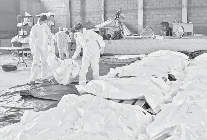  ?? Foto Ap ?? Trabajador­es del servicio médico forense mueven cuerpos en una morgue de Escuintla, Guatemala