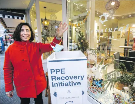  ?? ADRIAN LAM, TIMES COLONIST ?? Natalie Grunberg-Ferreira, owner of The Natural Hair Salon, shows off the mask-recycling receptacle in front of her business on View Street.