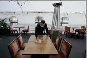  ?? RICH PEDRONCELL­I — THE ASSOCIATED PRESS FILE ?? Fabian Rodriguez cleans a table in an outdoor tented dining area of Tequila Museo Mayahuel restaurant in Sacramento.