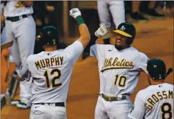  ?? JOSE CARLOS FAJARDO — STAFF PHOTOGRAPH­ER ?? The Oakland Athletics’ Marcus Semien, center, celebrates with Murphy after Murphy’s two-run home run in the fourth inning Thursday.