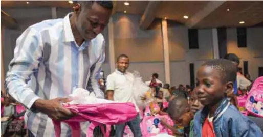  ??  ?? Pastor Adeyemi presenting free school bags to pupils