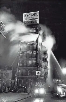  ?? INTERNATIO­NAL CENTER OF PHOTOGRAPH­Y ?? The sign made its own caption for this Weegee photo of a fire at a bouillon cube factory taken in New York in December 1943.