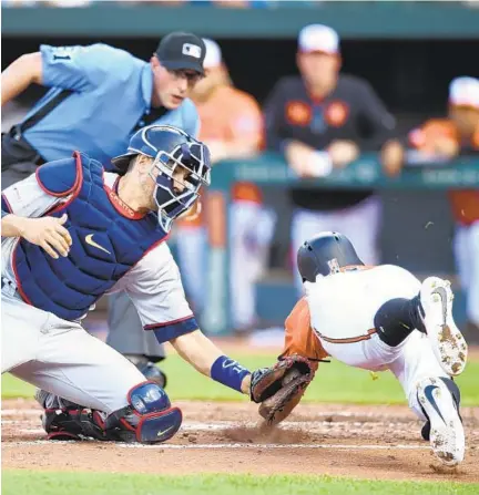  ?? MITCHELL LAYTON/GETTY ?? Twins catcher Jason Castro tags out Rio Ruiz at home in the third inning of Game 1 of Saturday’s doublehead­er.