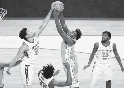  ?? JARED C. TILTON/GETTY IMAGES ?? Virginia Tech forward Keve Aluma, left, blocks the shot attempt of North Carolina’s Day’Ron Sharpe during an ACC quarterfin­al on March 11. Aluma leads the Hokies with 15.6 points and 8.0 rebounds a game and has shot 48.9% from the floor. He first attended Wofford, but then followed coach Mike Young to Blacksburg.