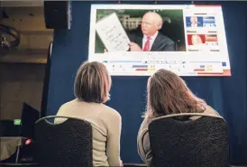  ?? Brandon Bell / Getty Images ?? Two women watch election results during a run-off election night party at Grand Hyatt Hotel in Buckhead on Tuesday in Atlanta.