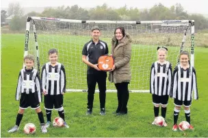  ??  ?? Adam Lee and Amy Chambers (centre) with Huncoat United FC’s new defibrilla­tor and players from the under 9s and under 10s teams.