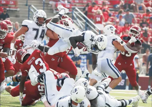  ?? Gary Kazanjian / Associated Press ?? UConn running back Kevin Mensah goes up high for a short gain against Fresno State during the first half on Saturday in Fresno, Calif.