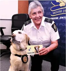  ??  ?? Kane, a yellow Labrador retriever, and his handler Donna Blondeau pose with a new book that talks about how the four-legged officer can support children and adults who have been hurt by events. Photo by Jason G. Antonio