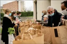  ??  ?? Distributi­on de sacs remplis de produits divers préparés par les bénévoles