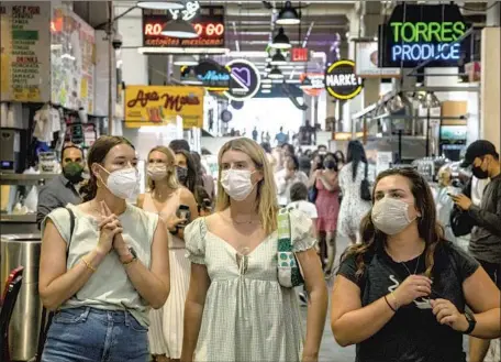  ?? Brian van der Brug Los Angeles Times ?? VISITORS HAVE their masks on at the Grand Central Market in downtown L.A. on Tuesday. The White House defended public health officials for changing their mask guidance “based on evolving data.” “That’s what they should be doing,” Press Secretary Jen Psaki said.