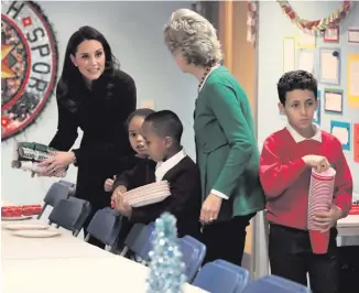  ??  ?? Clockwise from main: the Duchess of Cambridge helps with setting up the Rugby Portobello Trust’s Christmas party, which included children affected by the Grenfell Tower fire, at its community centre in North Kensington yesterday; the Duchess speaks to...