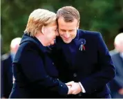  ?? PHILIPPE WOJAZER/POOL PHOTO VIA AP ?? French President Emmanuel Macron, right, and German Chancellor Angela Merkel embrace Saturday after unveiling a plaque in the Clairiere of Rethondes during a ceremony for Armistice Day, 100 years after the end of World War I, in Compiegne, north of Paris, France.